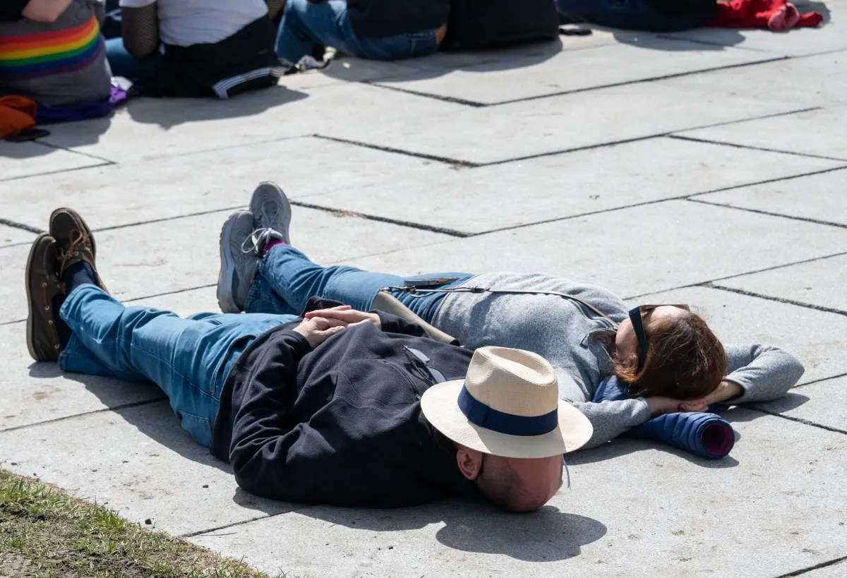 Two people lying on the ground, relaxing in the sun.