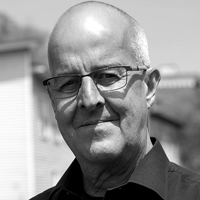 A black and white photo of a man wearing glasses.
