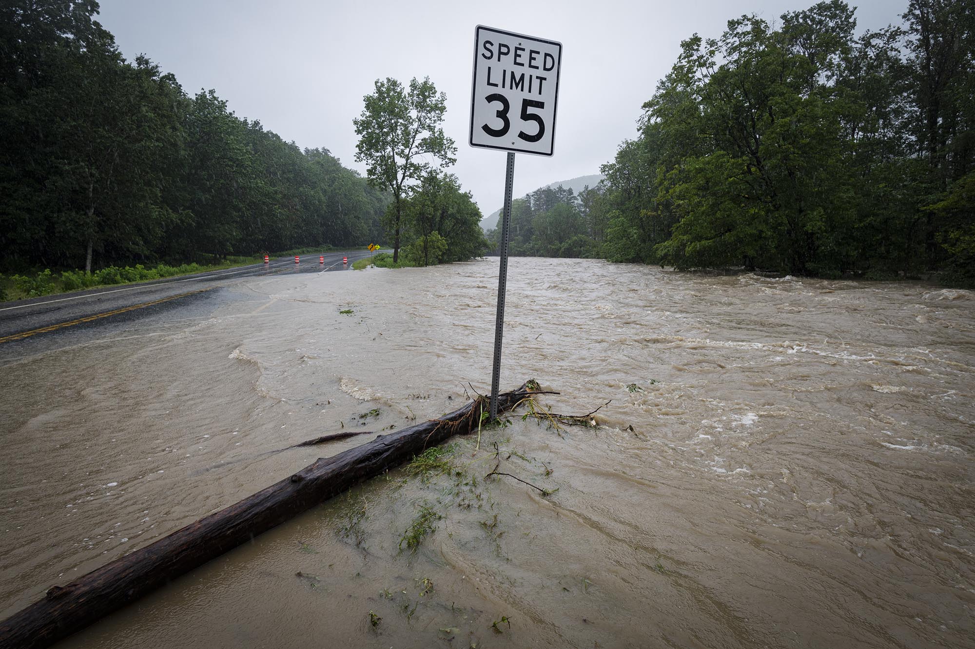 a road sign in the middle of a flooded road.