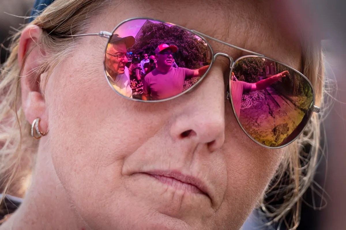 a woman's face is reflected in a pair of sunglasses.
