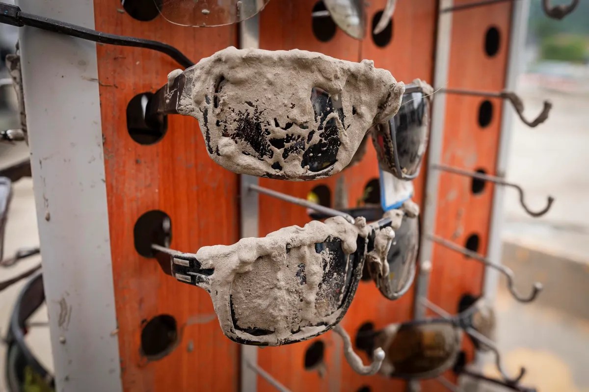 a pair of muddy sunglasses hanging on a rack.