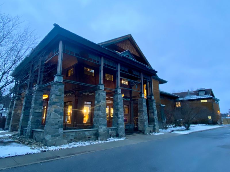 A large stone building is lit up at dusk.