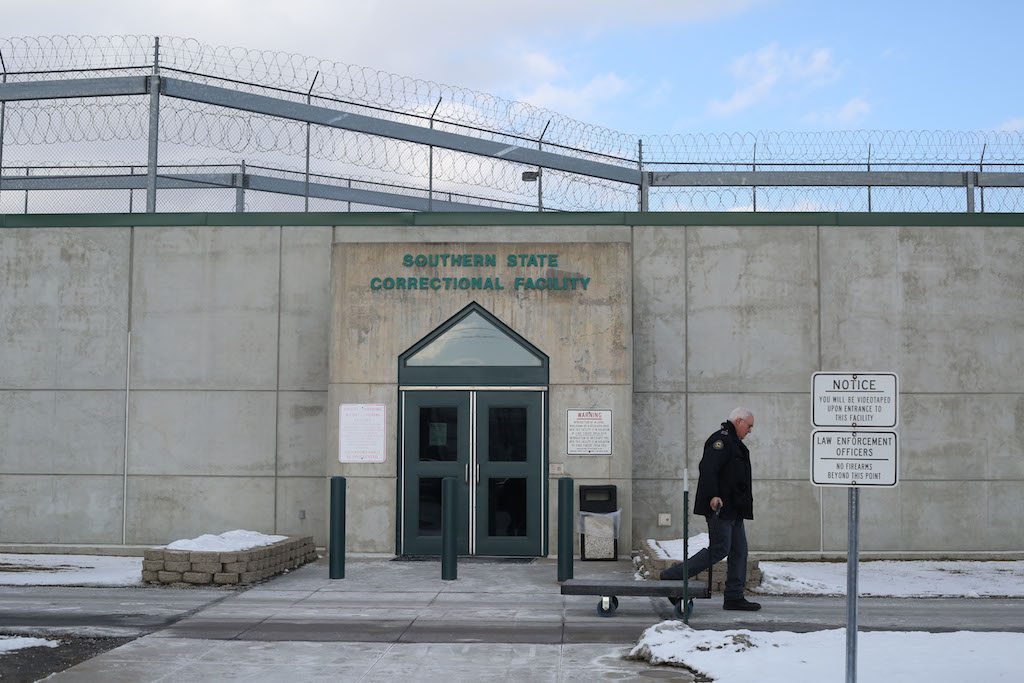 A man walking outside a prison.