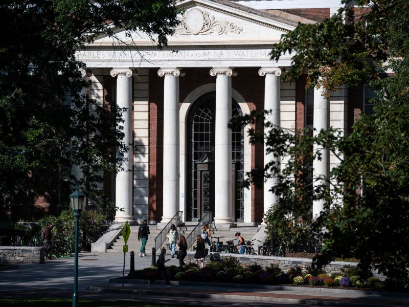 A large building with columns and trees in the background.