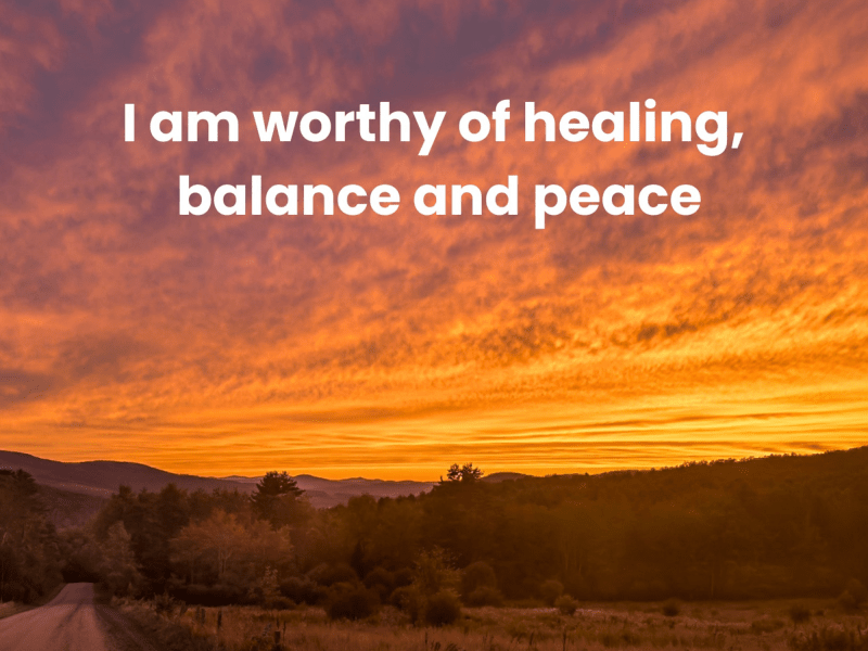 Orange sunset sky over a landscape with trees and hills; text reads, "I am worthy of healing, balance and peace.
